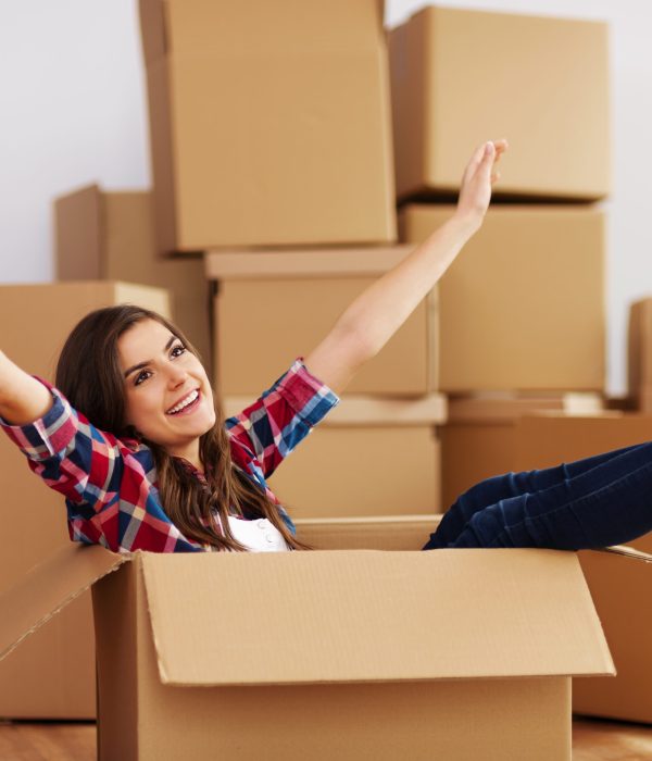 cheerful-woman-sitting-in-cardboard-box-scaled.jpg